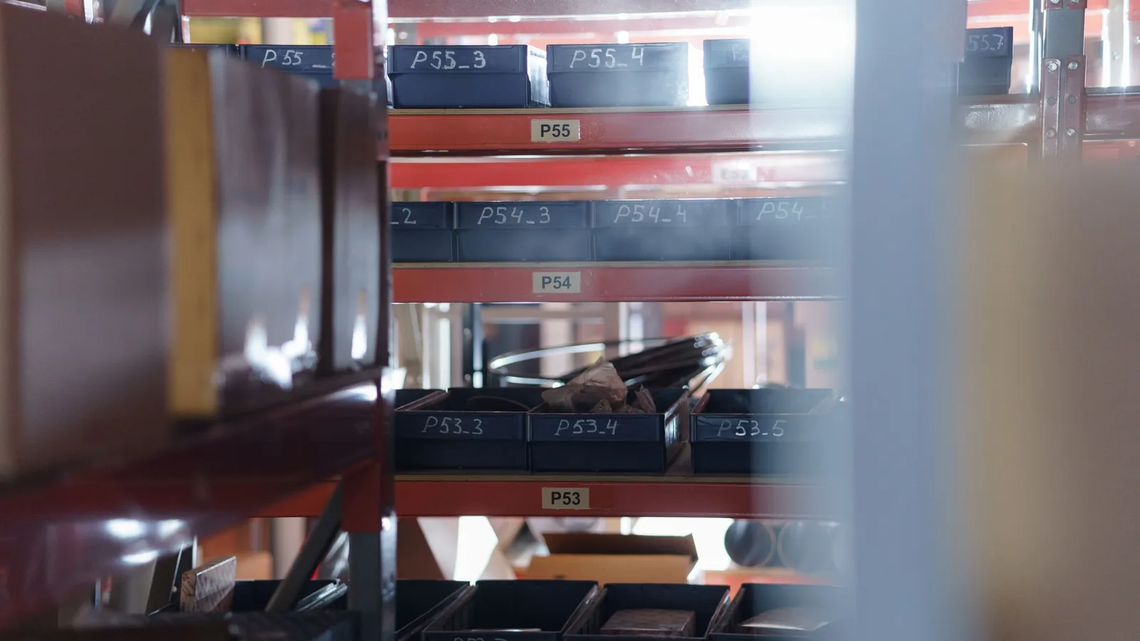 Warehouse shelving with numbered storage bins labelled P53 to P55