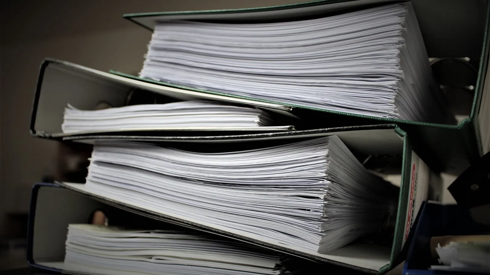 Stacks of thick binders filled with printed documents