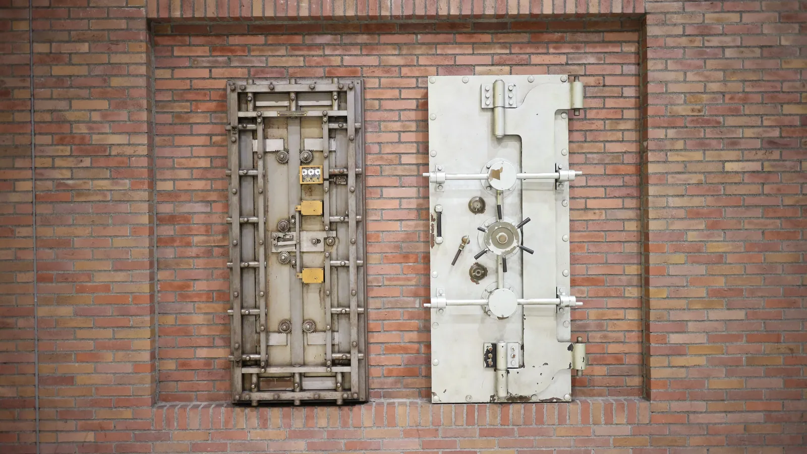 Two heavy steel vault doors set into an old brick wall
