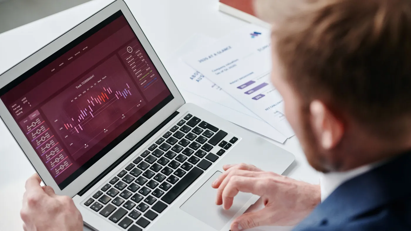 A person in an office reviewing a business analytics dashboard on a laptop screen